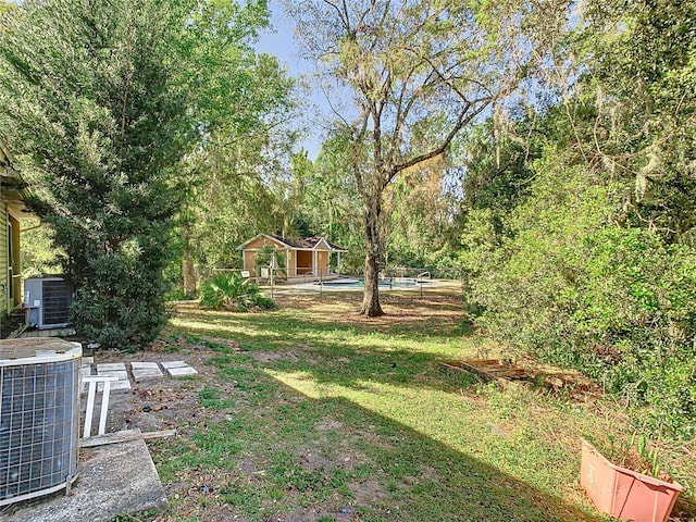 view of yard with an outbuilding, central AC unit, and an outdoor pool