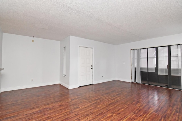 spare room with a textured ceiling and dark wood-type flooring