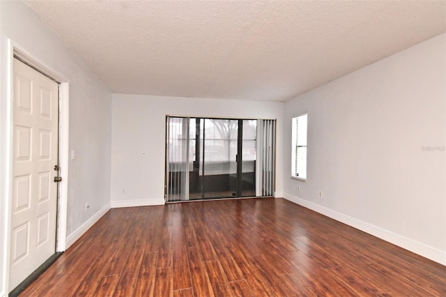 954 Courtyard Ln Unit 11, Orlando, FL 32825 - unfurnished room with baseboards, a textured ceiling, and dark wood-style flooring