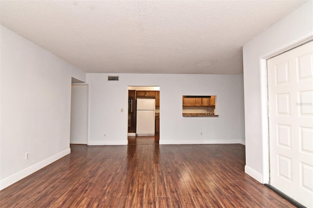 unfurnished room with a textured ceiling and dark hardwood / wood-style floors