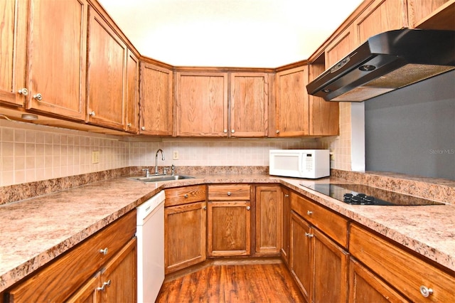 954 Courtyard Ln Unit 11, Orlando, FL 32825 - kitchen featuring a sink, brown cabinets, under cabinet range hood, white appliances, and dark wood finished floors