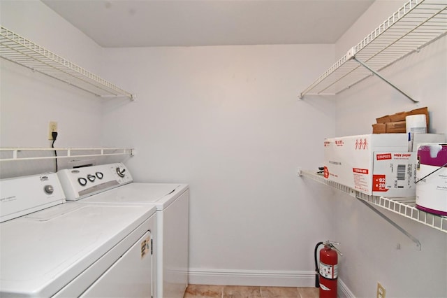 laundry room featuring washer and dryer and light tile patterned floors