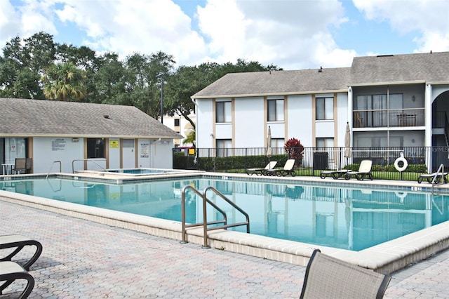 view of pool with a hot tub and a patio area