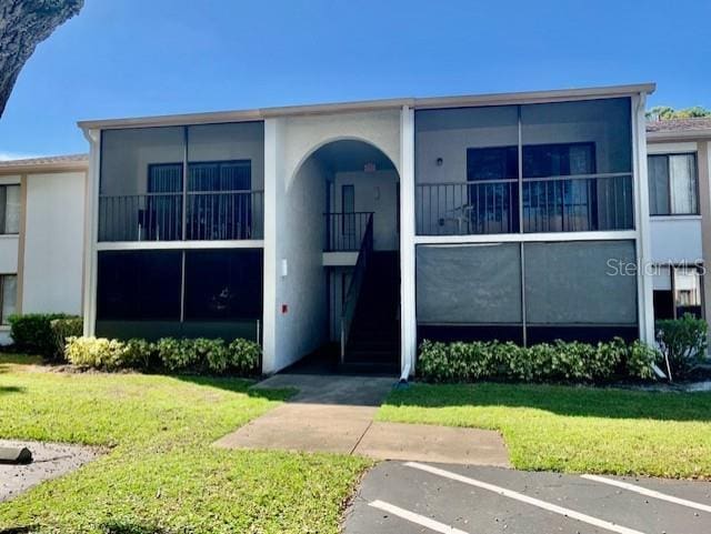 954 Courtyard Ln Unit 11, Orlando, FL 32825 - townhome / multi-family property with a front lawn, stucco siding, and uncovered parking