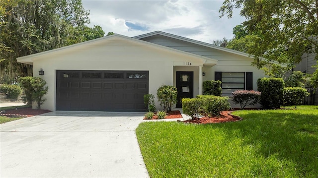 view of front facade featuring stucco siding, driveway, a front lawn, and an attached garage