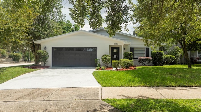 single story home with a garage and a front lawn