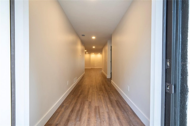 hallway featuring baseboards and visible vents