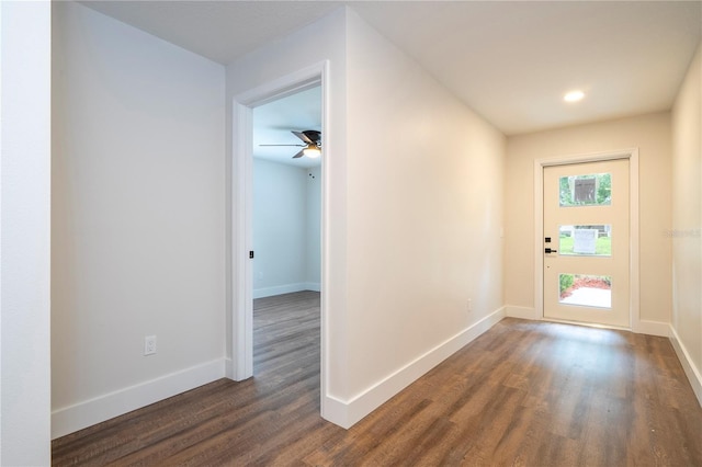 doorway with dark wood-type flooring and ceiling fan