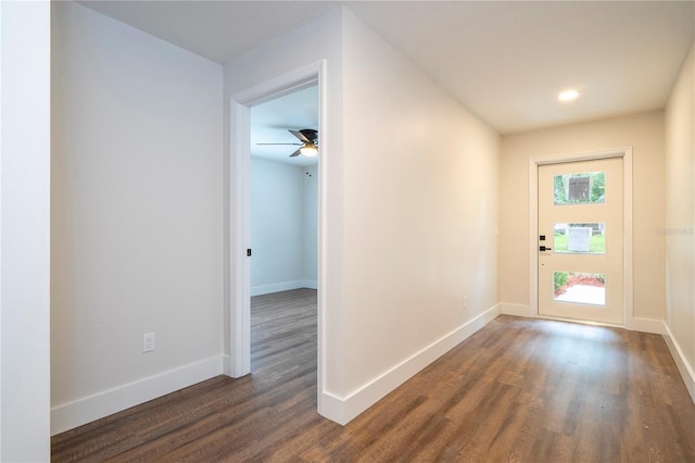 corridor with dark wood-type flooring and baseboards