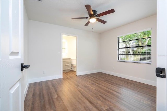 unfurnished bedroom with ceiling fan, hardwood / wood-style flooring, and ensuite bath