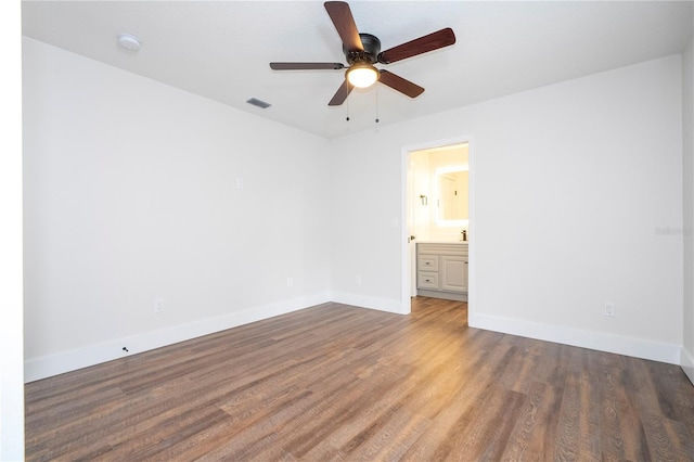 unfurnished bedroom with connected bathroom, wood finished floors, baseboards, visible vents, and ceiling fan