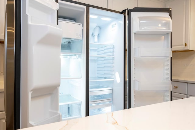 room details featuring freestanding refrigerator and tasteful backsplash
