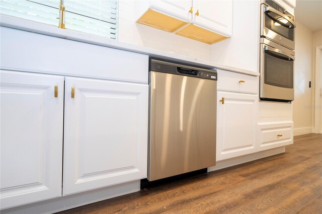 kitchen featuring dark hardwood / wood-style flooring, stainless steel appliances, and white cabinets