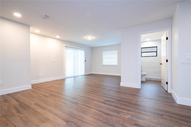 empty room with baseboards, visible vents, recessed lighting, and dark wood finished floors