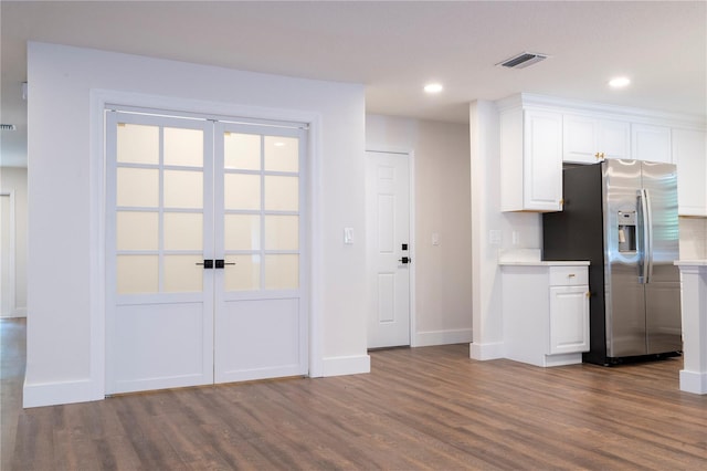 kitchen featuring stainless steel fridge with ice dispenser, light hardwood / wood-style flooring, white cabinets, and a wealth of natural light