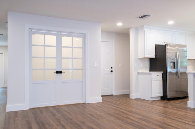 kitchen with light countertops, french doors, stainless steel fridge, dark wood-style floors, and white cabinets