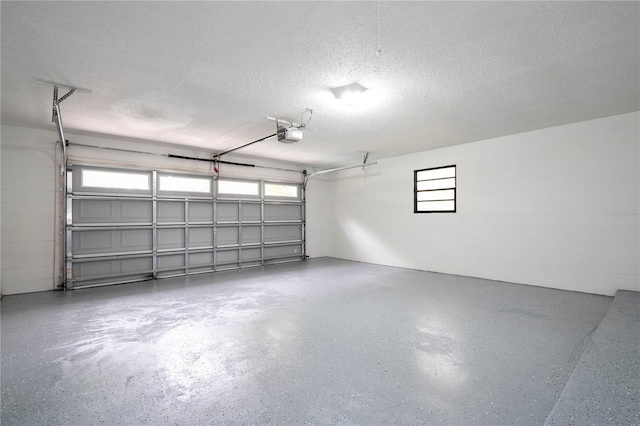 garage featuring a garage door opener and concrete block wall