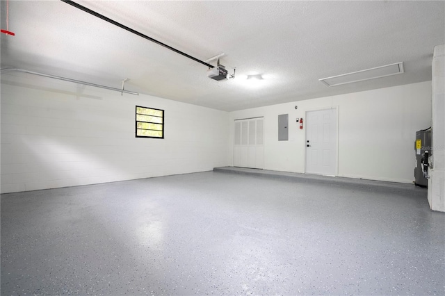 garage featuring concrete block wall, electric panel, electric water heater, and a garage door opener