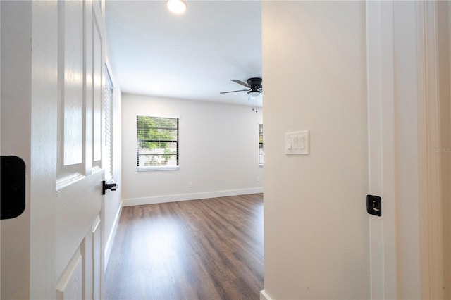 corridor with baseboards and wood finished floors