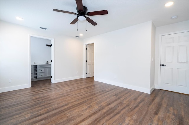 unfurnished bedroom featuring baseboards, dark wood-style floors, and visible vents