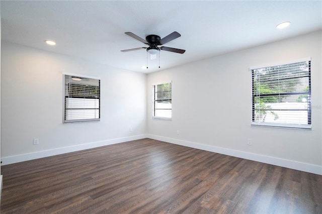 unfurnished room featuring plenty of natural light, ceiling fan, and dark hardwood / wood-style floors