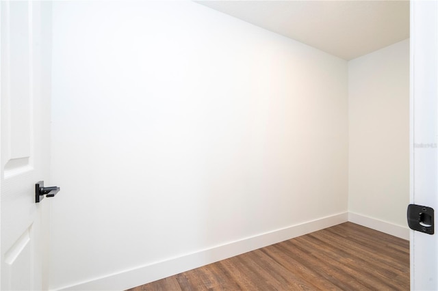 unfurnished room with dark wood-style floors and baseboards