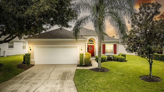 view of front of property with a yard and a garage