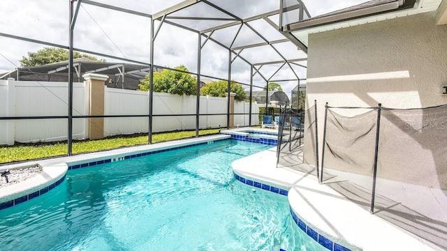 view of swimming pool featuring glass enclosure and an in ground hot tub