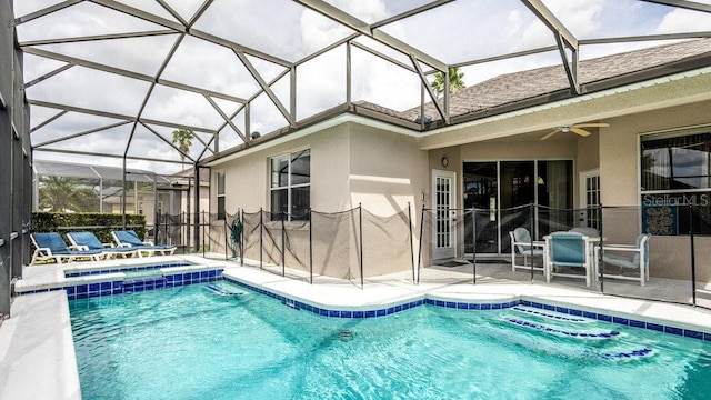 view of pool with glass enclosure, a patio area, ceiling fan, and an in ground hot tub