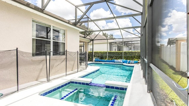 view of swimming pool featuring an in ground hot tub and a lanai