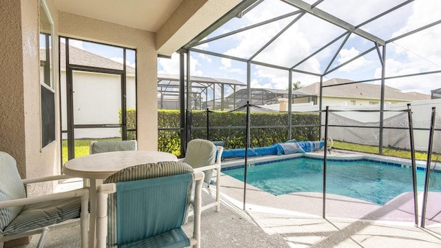 view of pool with glass enclosure and a patio