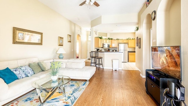 living room featuring light hardwood / wood-style flooring and ceiling fan