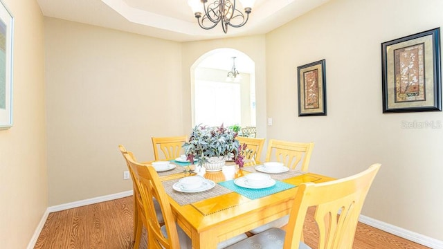 dining area featuring light wood-type flooring and an inviting chandelier