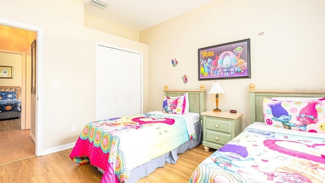 bedroom with light wood-type flooring and a closet