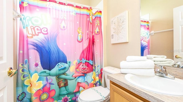 bathroom featuring vanity, toilet, and a shower with curtain