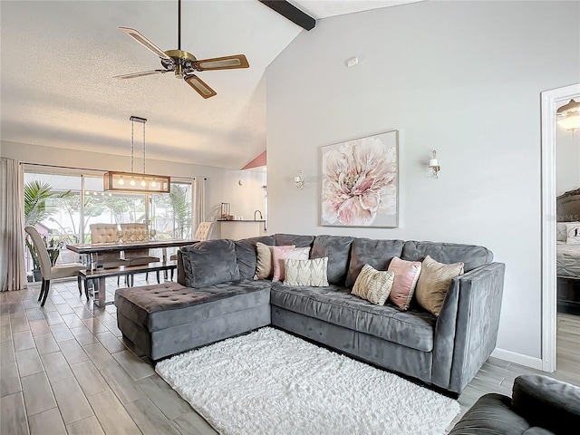 living room featuring light wood-type flooring, ceiling fan, beam ceiling, and a textured ceiling