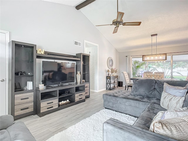 living room with ceiling fan, a textured ceiling, lofted ceiling with beams, and light hardwood / wood-style flooring