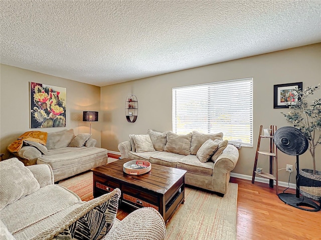 living room featuring a textured ceiling and light wood-type flooring