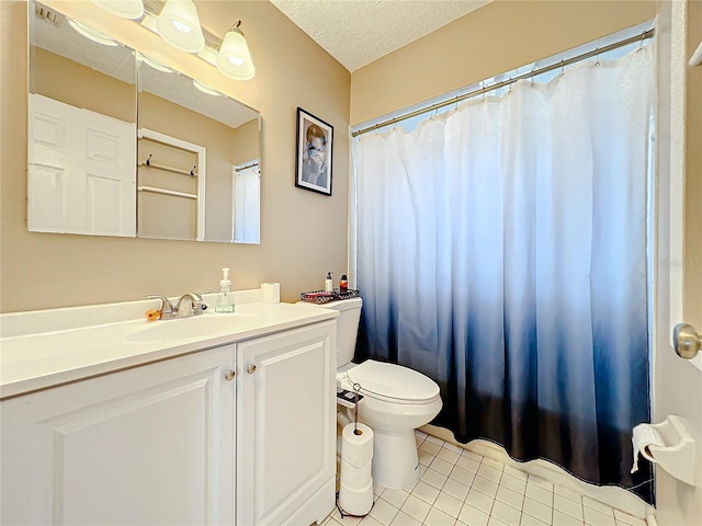 bathroom featuring vanity, toilet, tile patterned floors, and a textured ceiling