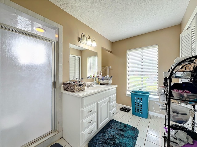 bathroom with vanity, a textured ceiling, walk in shower, and tile patterned floors