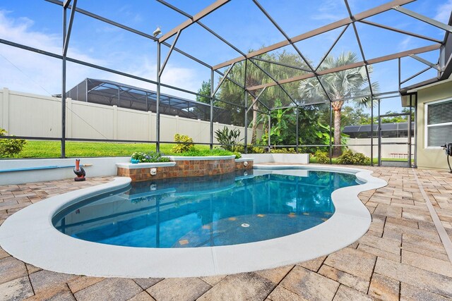 view of swimming pool featuring a patio area and a lanai