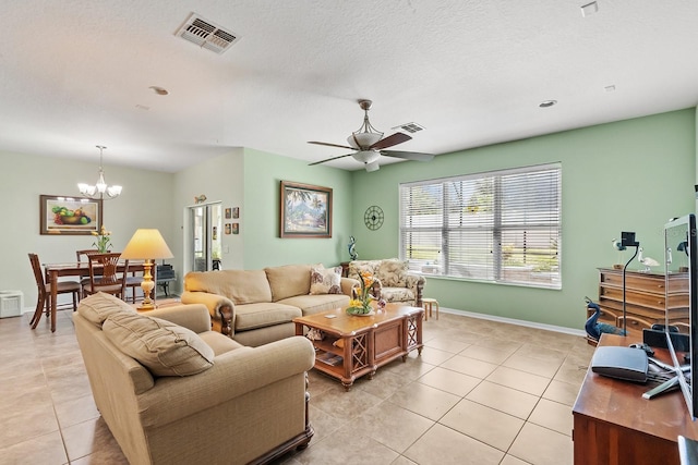 living room with a textured ceiling, light tile patterned floors, and ceiling fan with notable chandelier