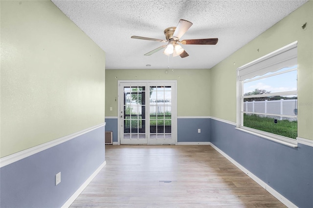 1005 Crescent Pkwy, Deland, FL 32724 - unfurnished room with baseboards, ceiling fan, a textured ceiling, and wood finished floors