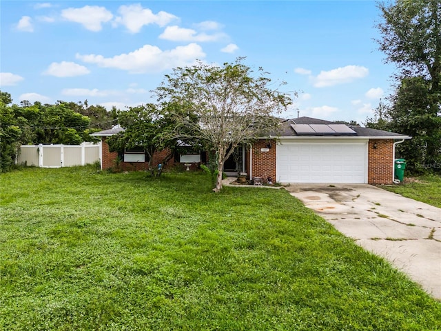 view of front of home with a garage, a front lawn, and solar panels