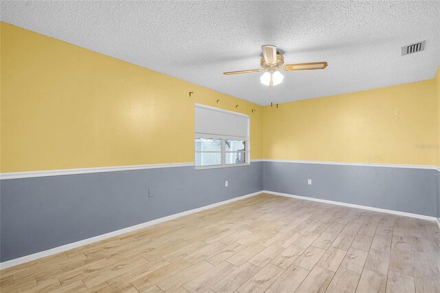 1005 Crescent Pkwy, Deland, FL 32724 - unfurnished room featuring visible vents, wood finished floors, baseboards, ceiling fan, and a textured ceiling