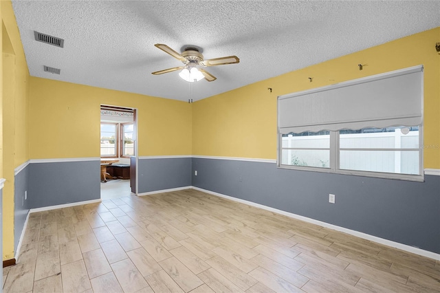 1005 Crescent Pkwy, Deland, FL 32724 - unfurnished room with visible vents, a textured ceiling, ceiling fan, and wood finished floors