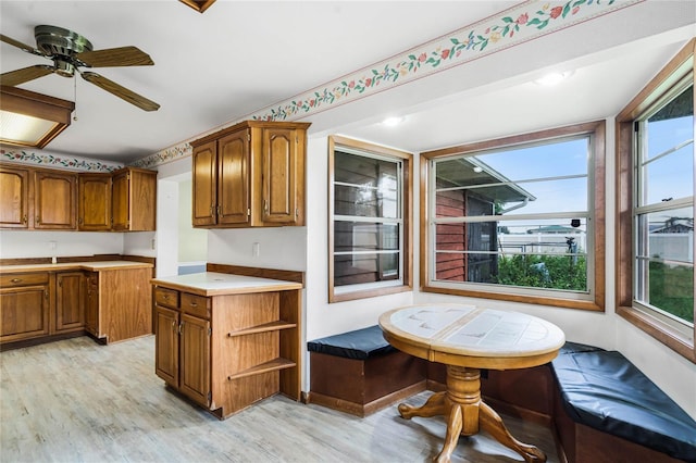 1005 Crescent Pkwy, Deland, FL 32724 - kitchen featuring brown cabinetry, light countertops, light wood finished floors, and a healthy amount of sunlight