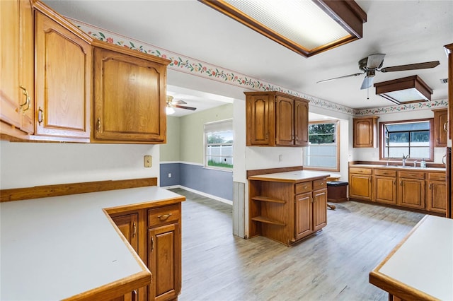 1005 Crescent Pkwy, Deland, FL 32724 - kitchen with a ceiling fan, brown cabinetry, a sink, and plenty of natural light