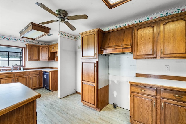 1005 Crescent Pkwy, Deland, FL 32724 - kitchen featuring brown cabinetry, a ceiling fan, a sink, light wood-style flooring, and dishwasher