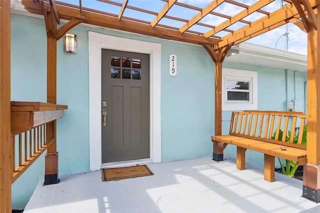 doorway to property with a pergola